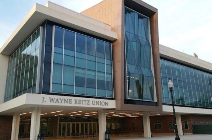 A modern building with a large glass facade, featuring the words "J. WAYNE REITZ UNION" in gray letters on the front.