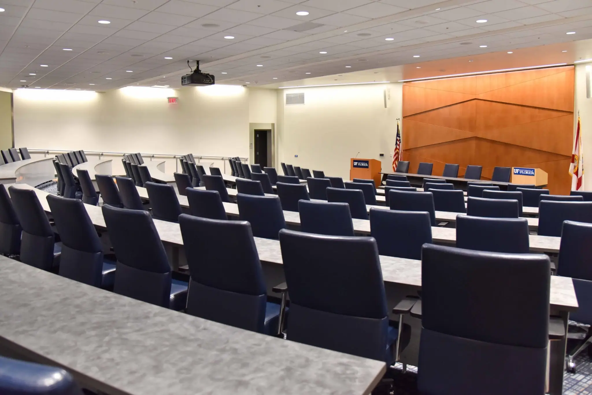 Empty conference room with rows of chairs and a podium at the front.